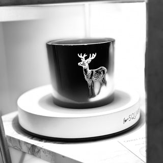 Black candle deer design on a white stand, placed on a marble