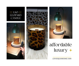 Wood wick candle in gold jar flickering on a cozy fall table with a warm mug and blanket beside it.