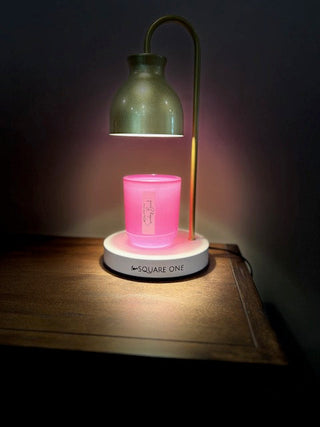 wickless candle in a hot pink jar under a candle warming lamp labeled sunday brunch