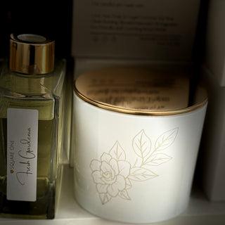 Candle with floral design and perfume bottle on a shelf