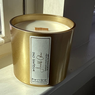 Gold candle jar with a label on a white surface