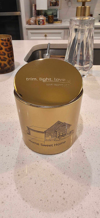 Gold candle jar with text on a countertop