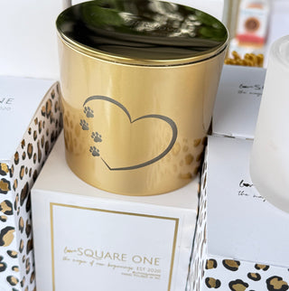 Gold cylindrical container with paw print design on a white surface with leopard print accents.