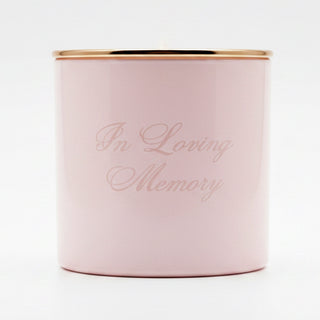 Pink candle with 'In Loving Memory' text on a blurred background