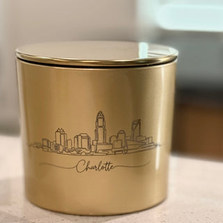 Gold container with city skyline design and 'Charlotte' text on a neutral background