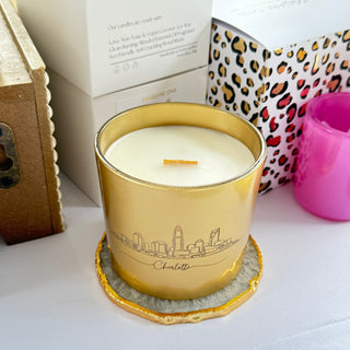 Candle in a decorative gold holder on a white surface with a leopard print item in the background.