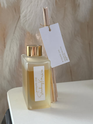 Bottle of perfume with a gold cap on a white countertop