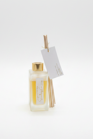 Diffuser bottle with reeds and a tag on a white background