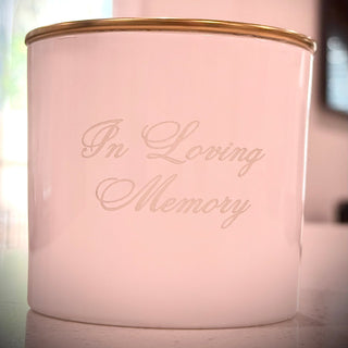 White candle with 'In Loving Memory' text on a blurred background