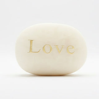 White stone with 'Love' engraved on a white background