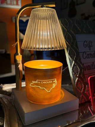 Candle with 'North Carolina' engraving on a stand with blurred background