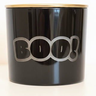 Black BOO candle with gold lid on countertop