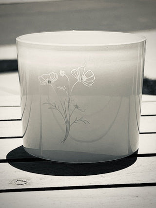 Hand-poured gardenia candle lit on a wood tray, evoking springtime and quiet moments of reflection- black and white photo