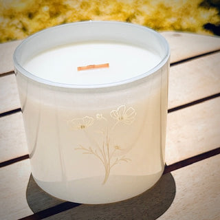 Fresh Gardenia candle in white jar with dainty floral engraving, styled with soft neutral decor on a wood table
