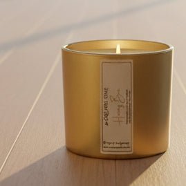 Gold Square One Honey Bee candle jar in a white tray with packaged candles in the background.⠋