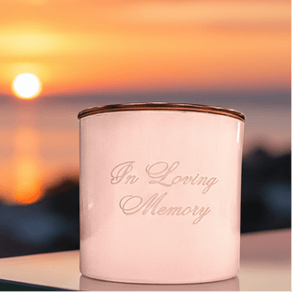 Candle with 'In Loving Memory' text against a sunset sky