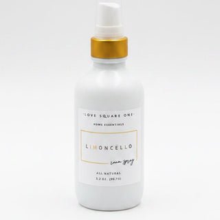 A white bottle of Love Square One Linoncello home fragrance spray with a gold collar and clear cap, resting on a light marble surface.
