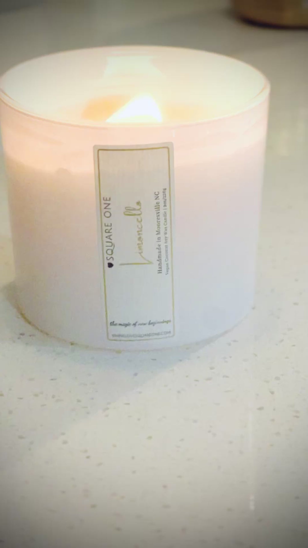 video of a limoncello candle burning on a marble countertop