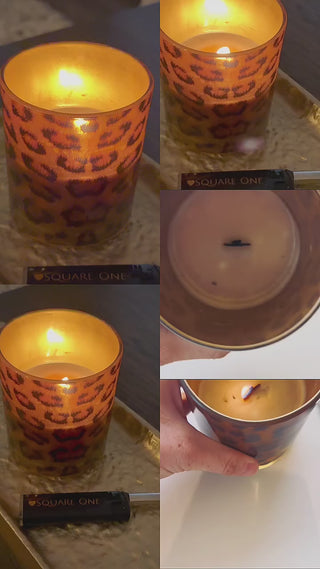 video of our leopard printed candle burning. The flame gently glows through and a gold tray with a black love square one lighter 