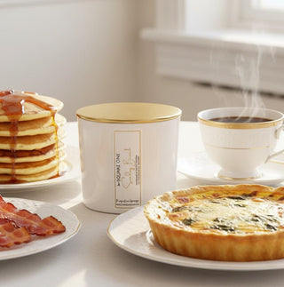 quiche and sunday brunch candle in background next to a cup of coffee